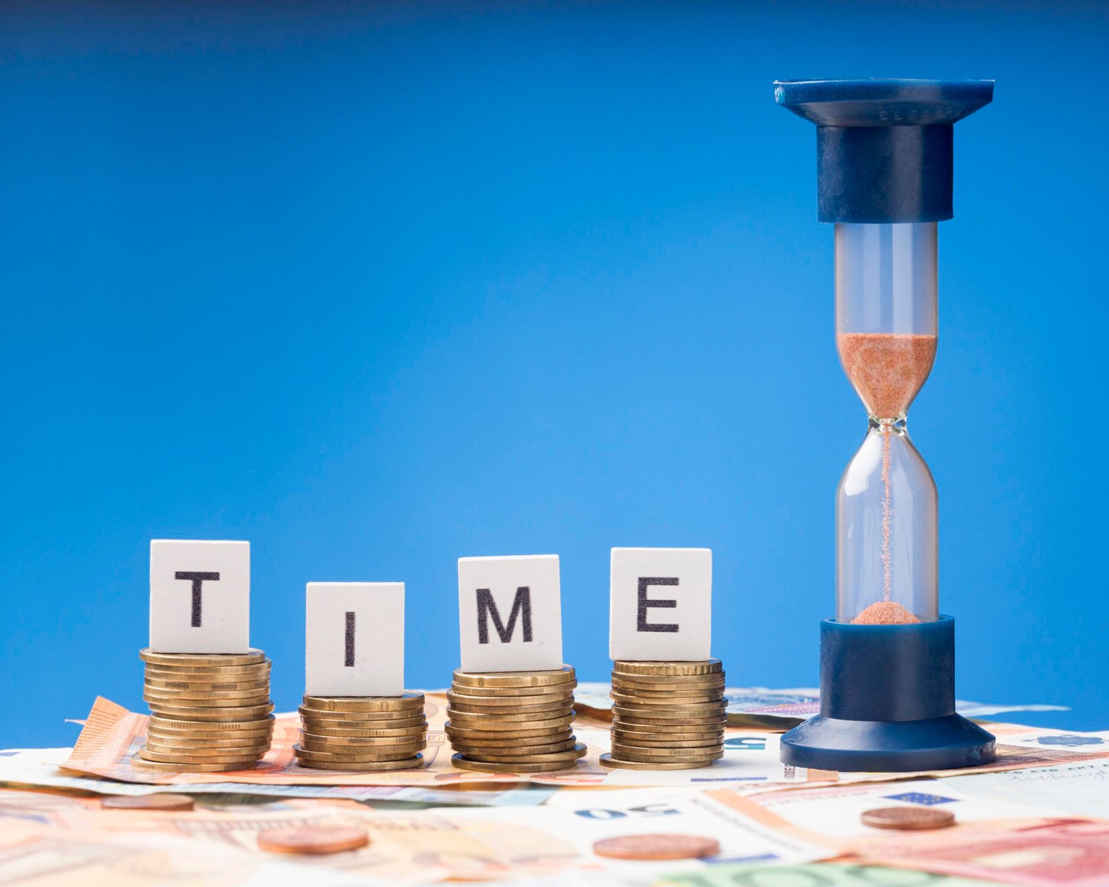 a hourglass and stacks of coins